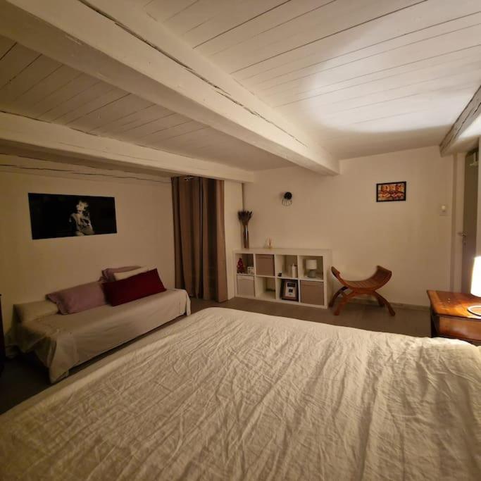 a bedroom with a large bed and a table at La Maison Thébaïde in Mortagne