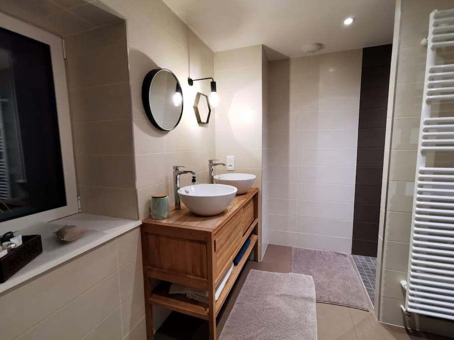 a bathroom with a white sink and a mirror at La Maison Thébaïde in Mortagne