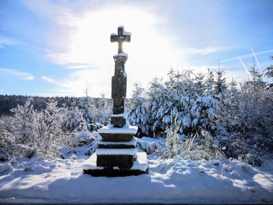 a cross on top of a snow covered field at La Maison Thébaïde in Mortagne