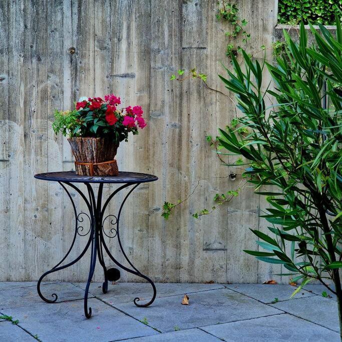 a table with a vase of flowers on it at La Maison Thébaïde in Mortagne