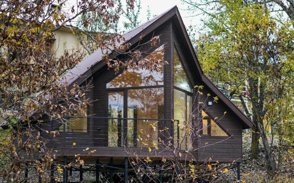 een klein huisje met een zwart dak bij Cottage Am Museum in Mestia