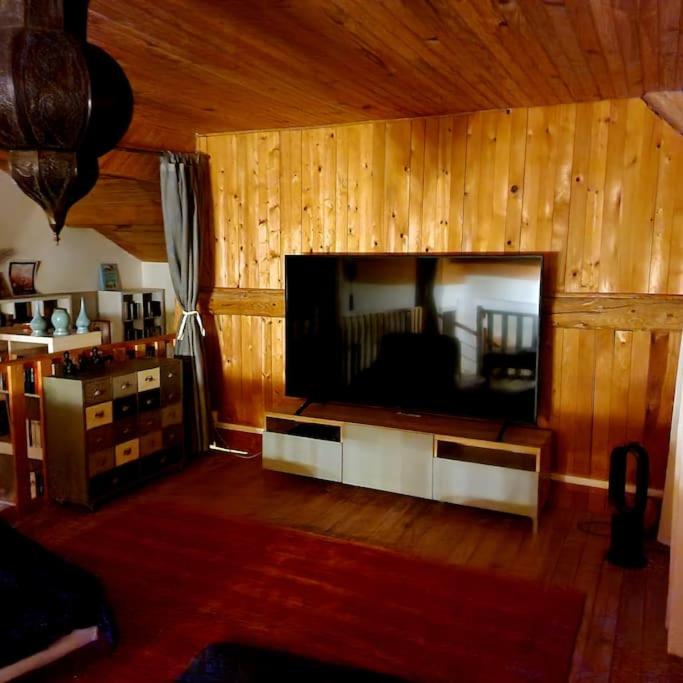 a living room with a large flat screen tv at La Maison Thébaïde in Mortagne