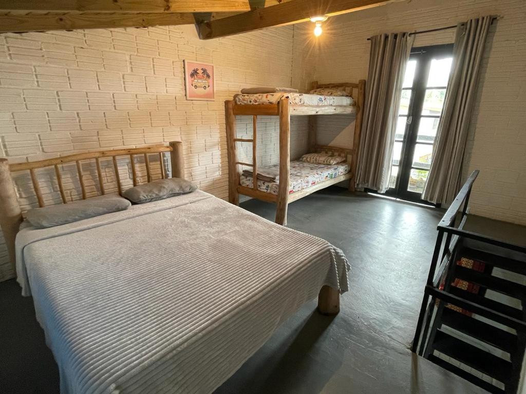 a bedroom with two bunk beds and a window at Solar da Suzi in Praia do Rosa