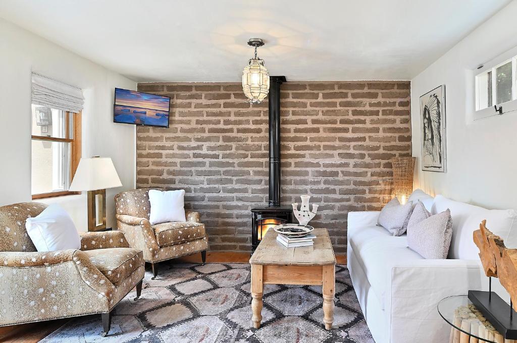 a living room with two couches and a brick wall at Dos Hermanas Casita 2 Downtown Courtyard in Santa Fe