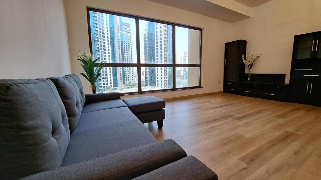 sala de estar con sofá y ventana grande en The White Stay, en Dubái