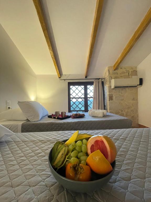 a bowl of fruit on a bed in a room at Windy Inns ( Maistros I ) in Vouyiáton