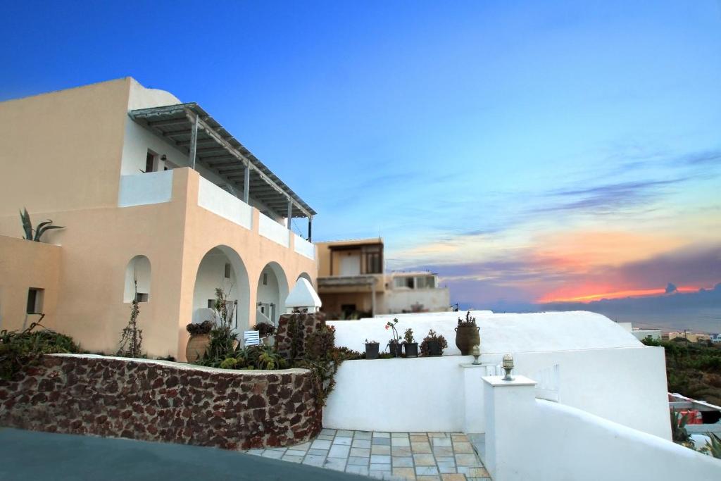 a view of a house with a sunset in the background at Muses Cycladic Suites in Oia