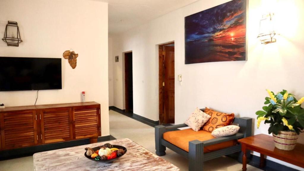 een woonkamer met een bank en een tv bij Imani House in Malindi