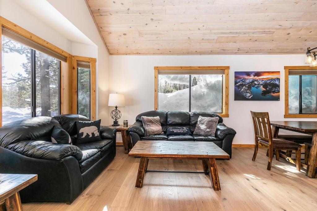 a living room with a leather couch and a table at Kokanee at Tahoe Donner - Charming 3 BR - Pool Table - Fireplace - Amenity Access! in Truckee