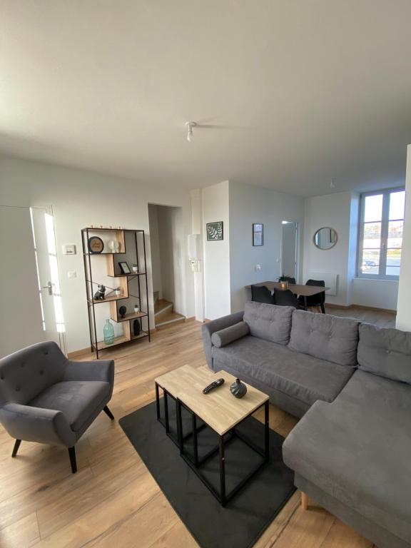 sala de estar con sofá y mesa en Le Duplex Tout Confort en Bressuire