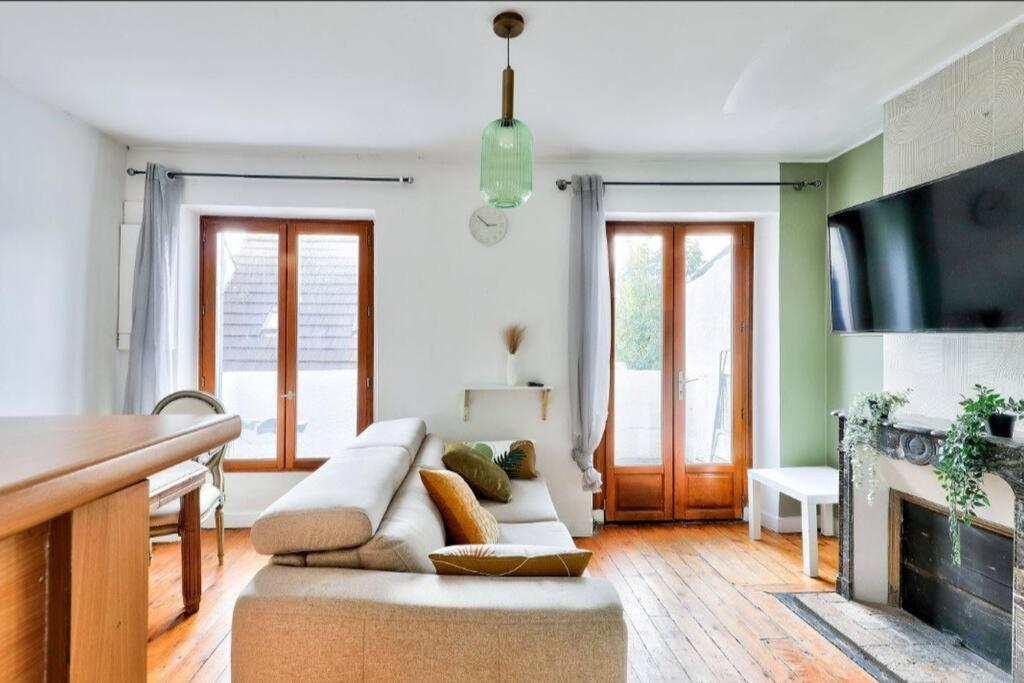 sala de estar con sofá blanco y chimenea en Charmant appartement T3 avec joli balcon terrasse, en Créteil