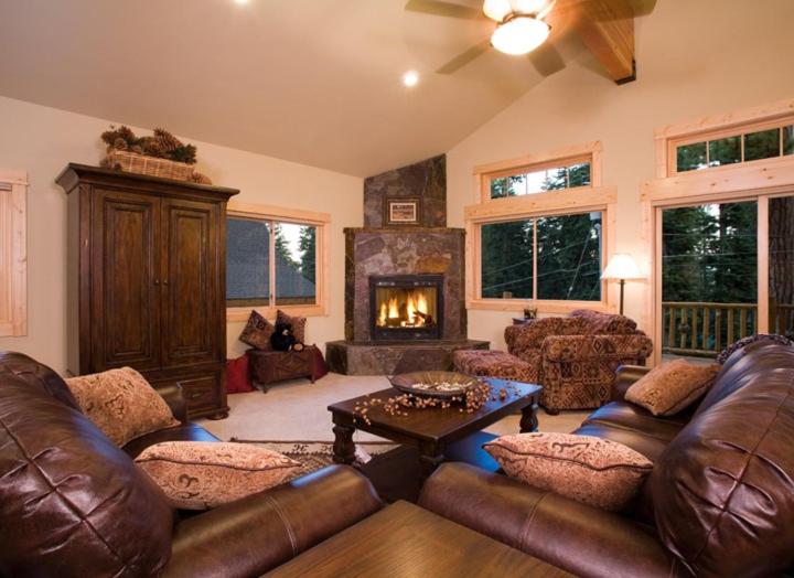 a living room with a leather couch and a fireplace at Olive Branch - Private Hot Tub, Media Room, Pet-Friendly, Near Northstar! in Carnelian Bay