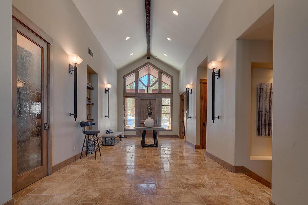 - un couloir avec une grande fenêtre et une table dans l'établissement Mountain Majesty at Grays Crossing - Luxury 4BR 4BA w Private Hot Tub, à Truckee