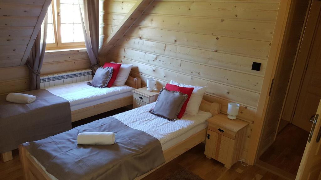 シュチルクにあるApartamenty Złoty Stokのログキャビン内のベッド2台が備わる部屋です。