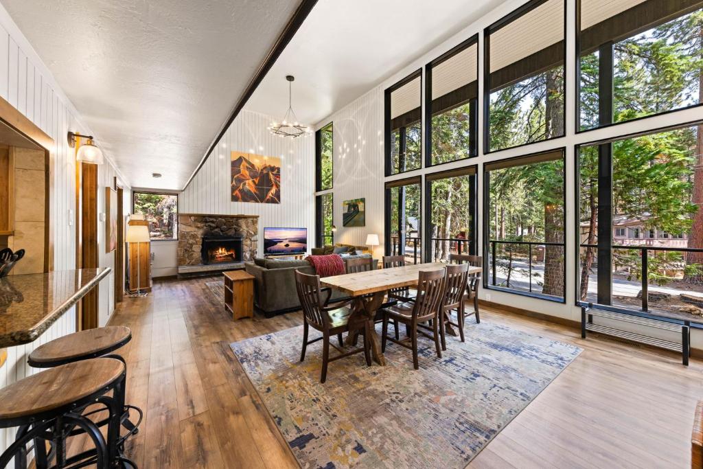 un soggiorno con tavolo, sedie e camino di Ellis Peak Retreat - Hot Tub, Wood Fireplace, Close to Tahoe City & Dining a Tahoe City