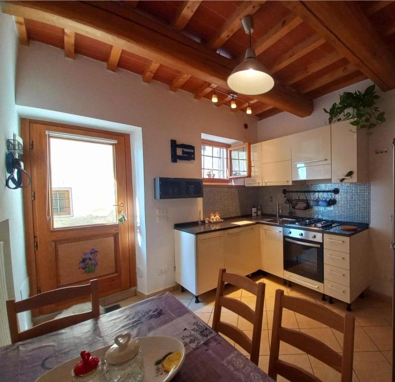 a kitchen with a table and chairs and a kitchen with a window at Casina Iris - Reggello in Reggello