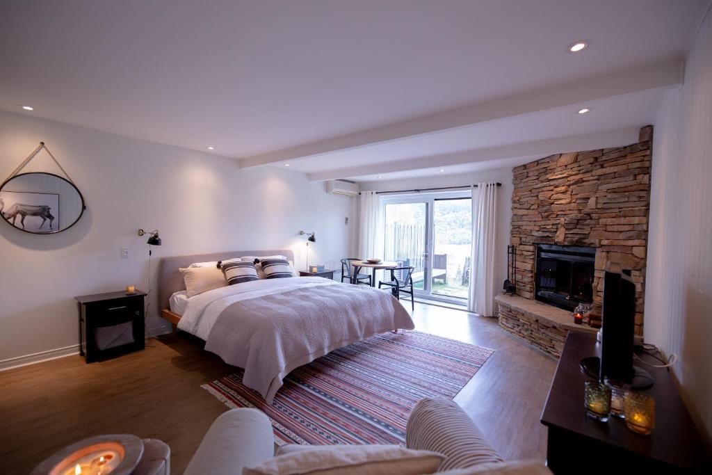 蒙特朗布朗的住宿－Amazing Lakemountain View 5min To Tremblant431，一间卧室设有一张大床和一个壁炉