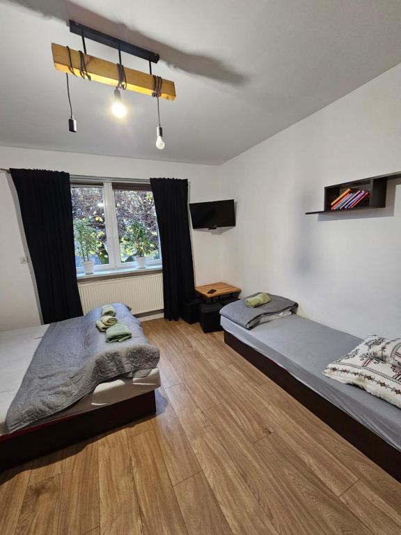 a bedroom with two beds and a wooden floor at Zawoja Nad Koroną z jacuzzi in Zawoja