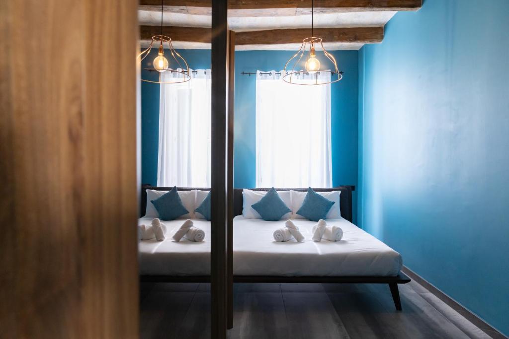 a bedroom with a bed with blue walls and a window at Valletta Stylish 2 Beds Flat in Valletta