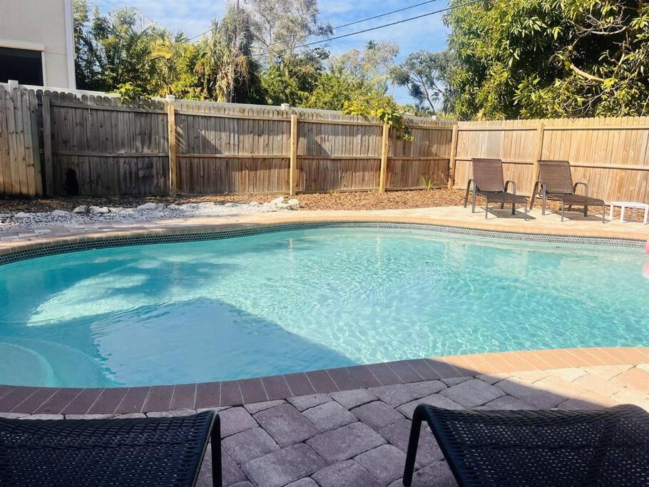 - une piscine avec 2 chaises et une clôture dans l'établissement Large Backyard with heated pool/ Near Beach, à Clearwater Beach