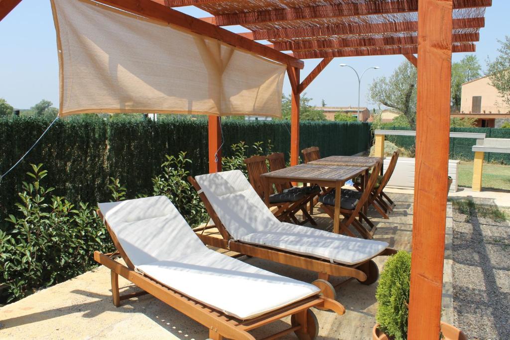 eine Terrasse mit einem Tisch und Stühlen unter einer Pergola in der Unterkunft Allotjament Activitats Bora Bora-Empordà in Verges