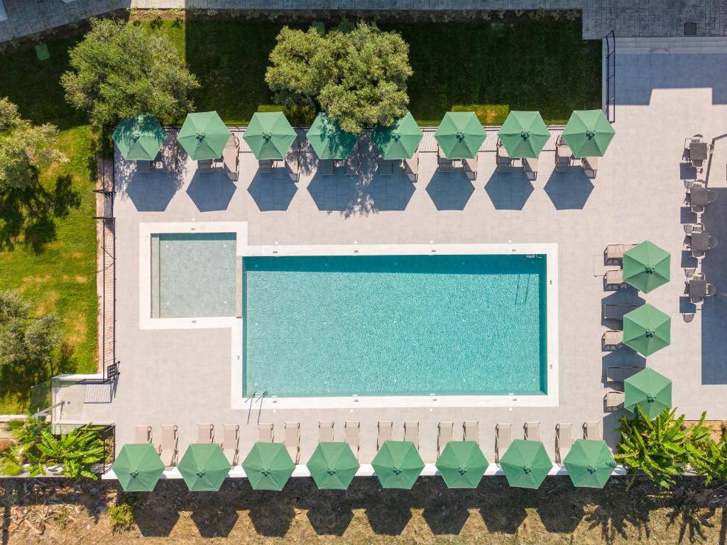 - une vue sur la piscine avec des parasols verts dans l'établissement Smaragdi Kos Hotel, à Kos