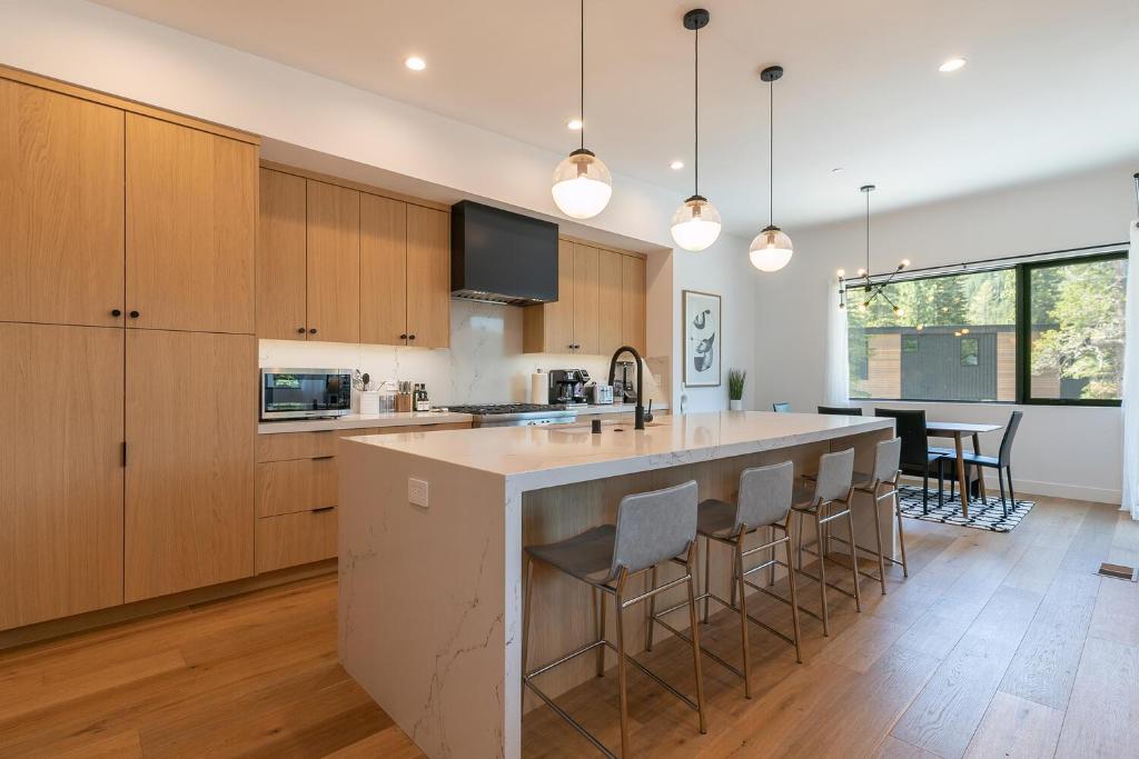 an open kitchen with a large island with bar stools at Powder Run - Newly Built Palisades 3 Bedroom Townhome - Minutes to Village in Olympic Valley