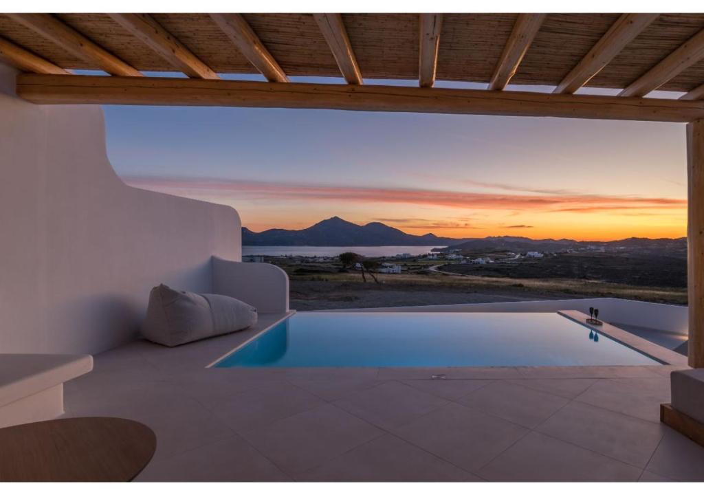 a villa with a swimming pool at sunset at Leuki Villa Milos in Adamas