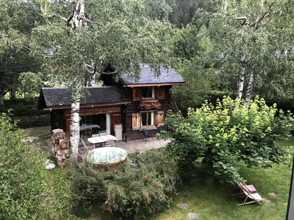 a small cabin in the woods with a deck at Mazot les Tines in Chamonix-Mont-Blanc