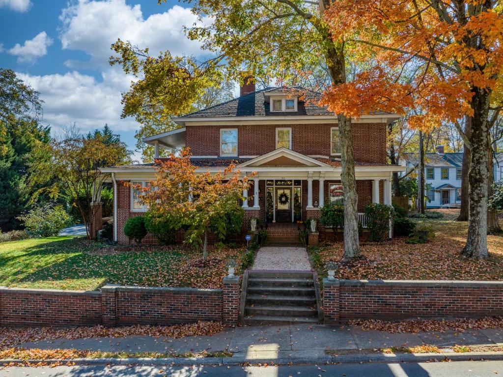 a brick house with fall leaves on the ground at The Inn on Front Street in Statesville