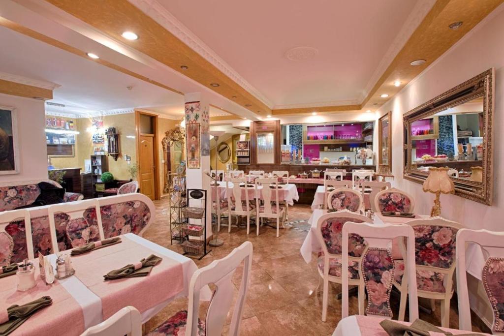 萨拉热窝Hotel Herc Sarajevo的一间有桌椅的餐厅