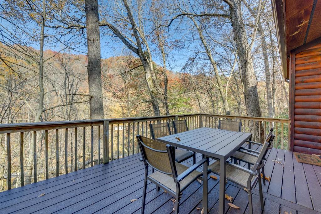 une terrasse en bois avec une table et deux chaises. dans l'établissement Mountain-View Waynesville Home with Creek Access!, à Waynesville