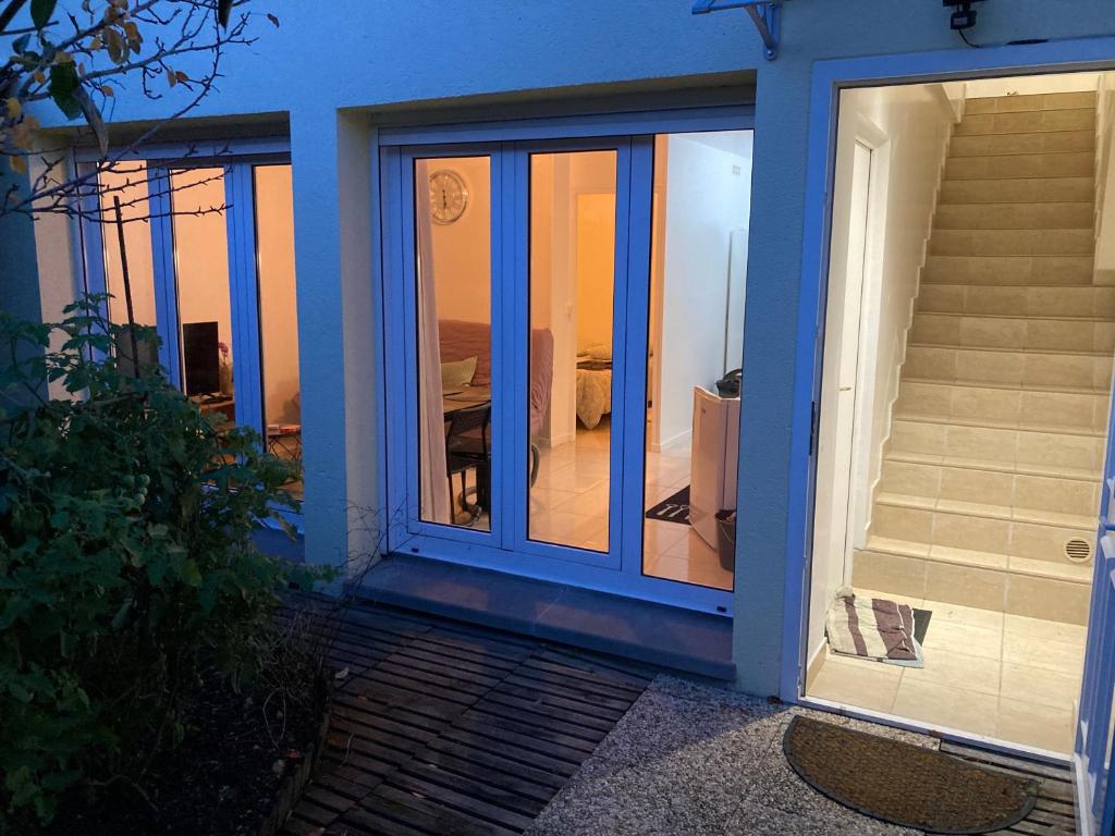 a blue door of a house with a view of a bedroom at La Maison des roses in Nanterre