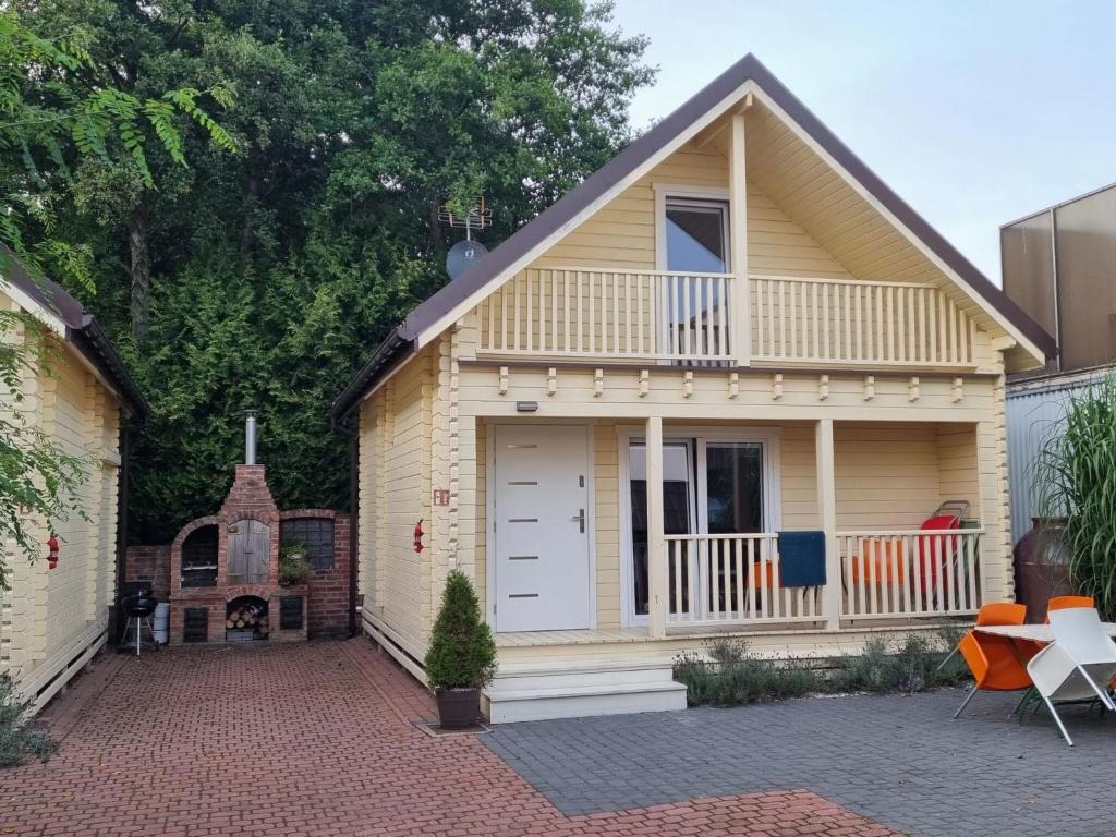 a small yellow house with a porch and a balcony at Holiday resort, Grzybowo in Grzybowo