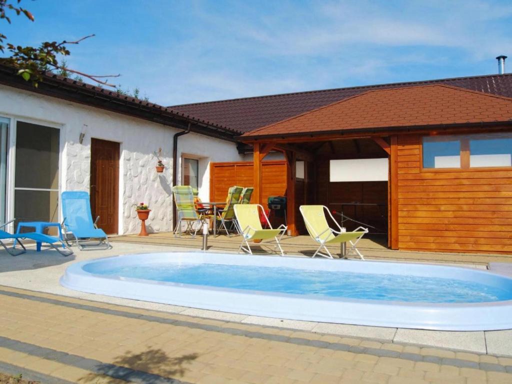 einen Pool mit Stühlen und ein Haus in der Unterkunft Terraced house with pool and sauna, Sieciemin in Sieciemin