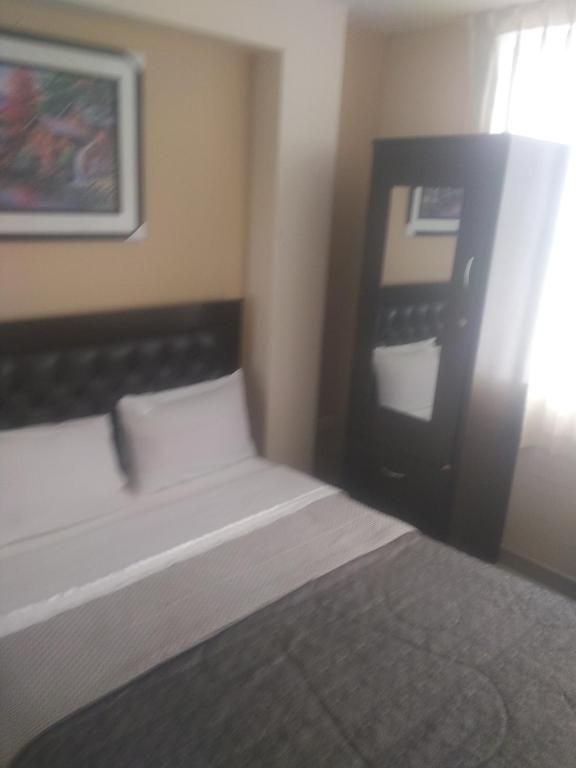 ein Schlafzimmer mit einem Bett und einem Bild an der Wand in der Unterkunft Hostal Chachani in Zamacola