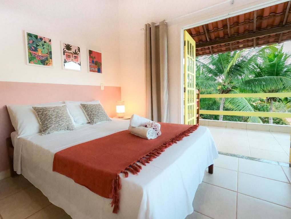 1 dormitorio con cama y ventana grande en Canto do Mar - Apartamentos e Casa com vista pro Mar - Cumuruxatiba en Cumuruxatiba