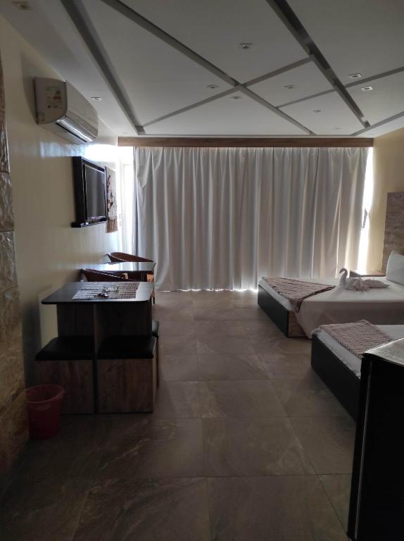 a hotel room with two beds and a television at pyramids view suite/vista piramidi in Cairo