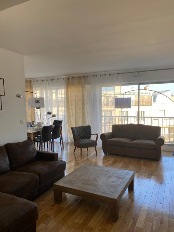 un salon avec deux canapés et une table dans l'établissement Le 7ème ciel, à Paris