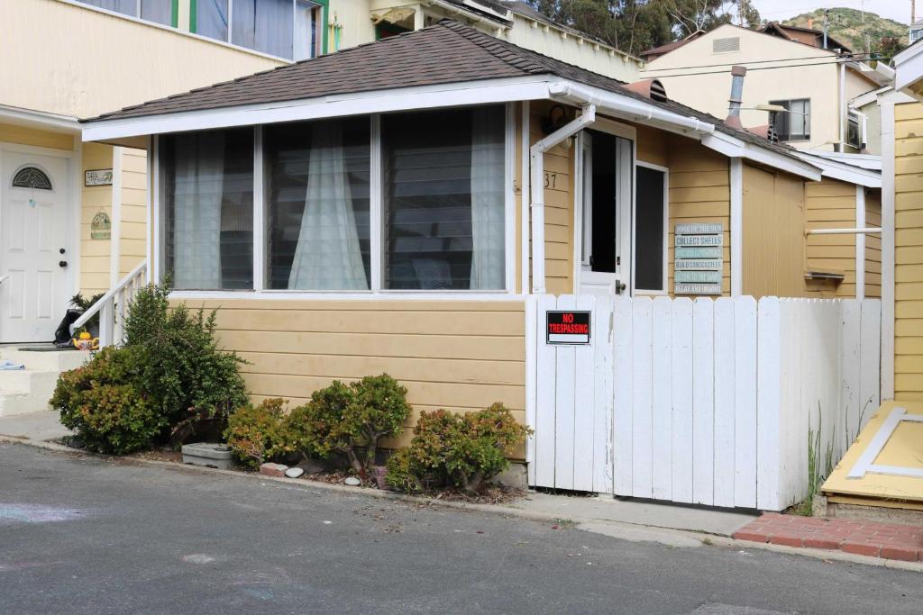 ein Haus mit einem weißen Tor und einem weißen Zaun in der Unterkunft Catalina Island Cottage - Walk to Main St and Beach! in Avalon