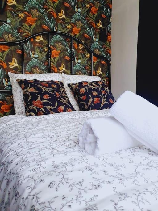 a bedroom with a bed with a floral wall at Le Lagon - 10 min aéroport et de Nantes in Rezé