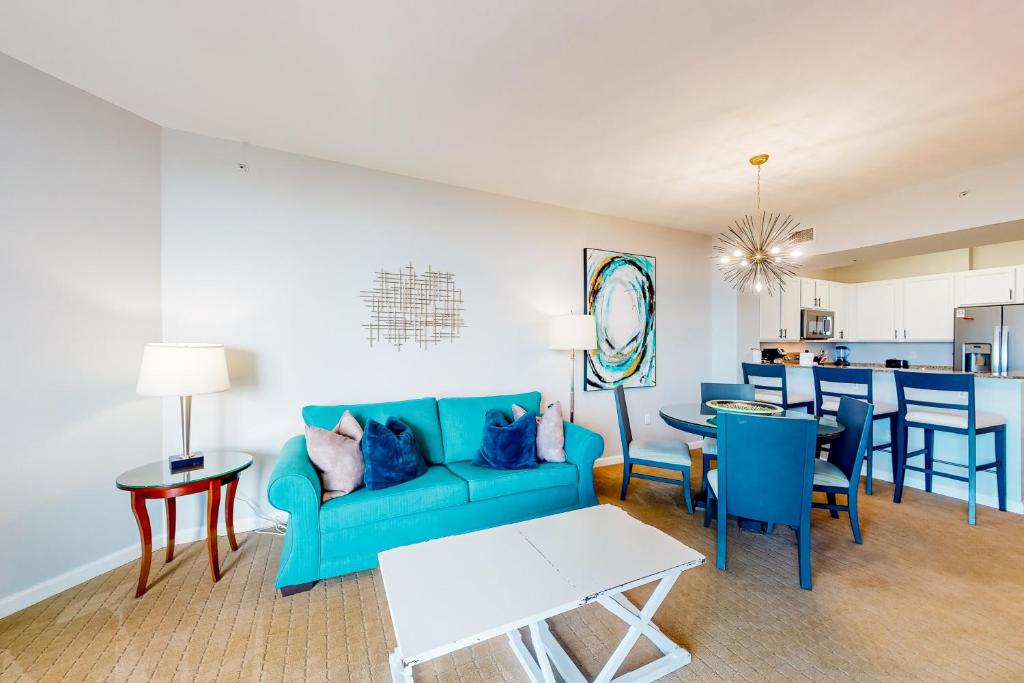 sala de estar con sofá azul y mesa en Palms of Destin 21206 en Destin