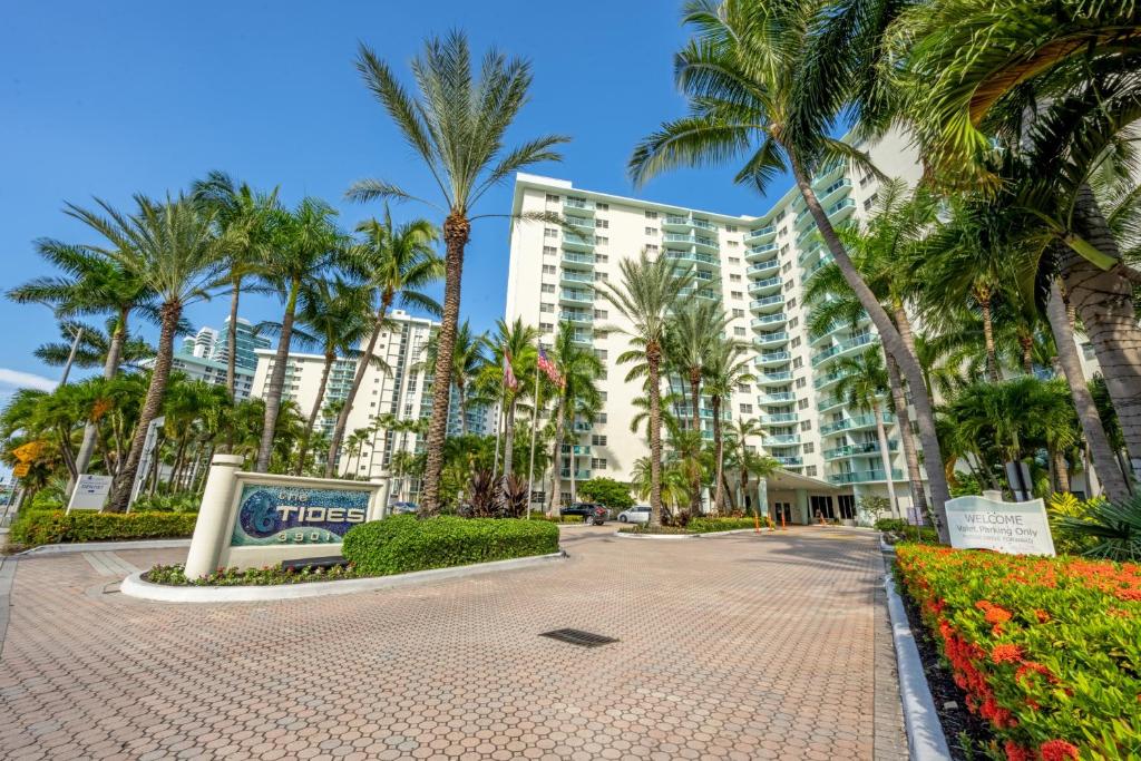 a large apartment building with palm trees in front of it at Tides on Hollywood Beach in Hollywood