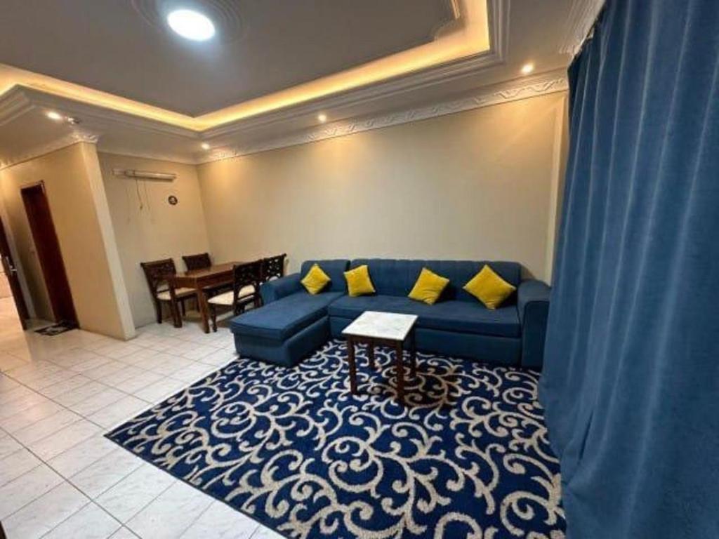 a living room with a blue couch and a table at كازا رست للوحدات السكنية in Ḩayy aş Şāliḩīyah