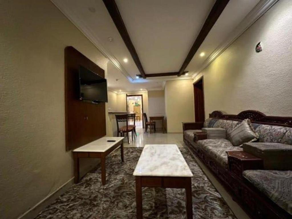 a living room with a couch and a table at كازا رست للوحدات السكنية in Ḩayy aş Şāliḩīyah