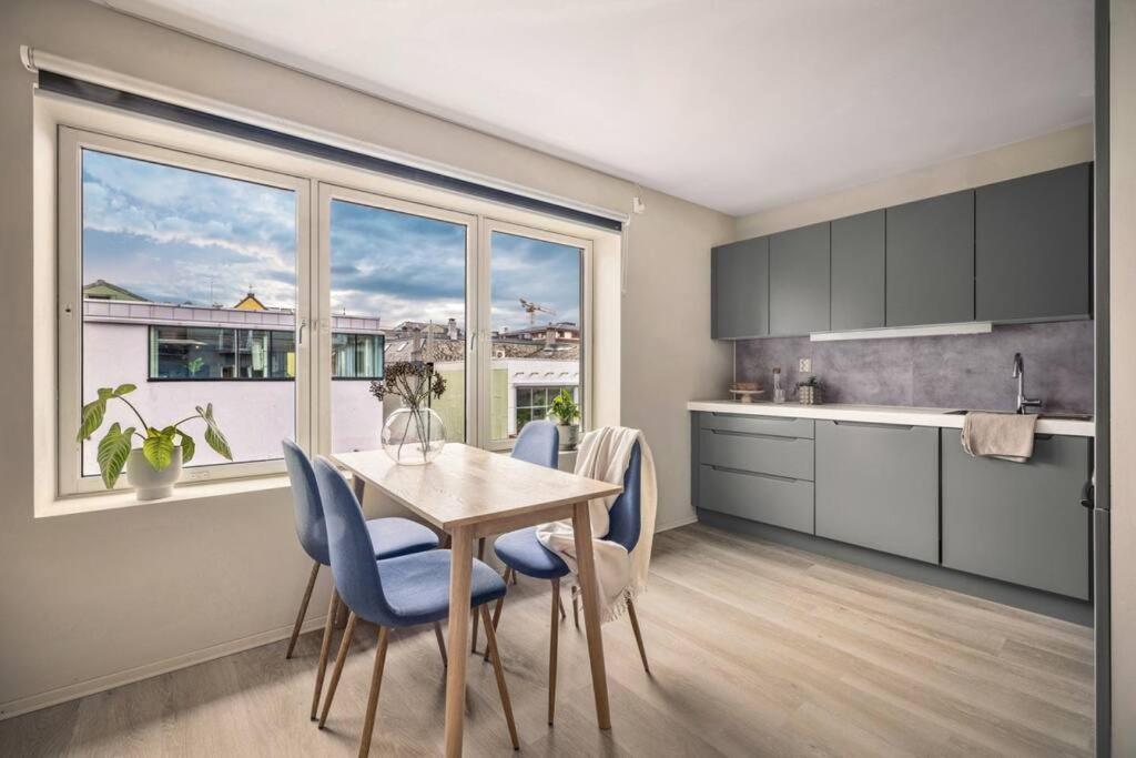 a kitchen with a table and chairs and a large window at New Couples Apartment In the Heart of Bergen in Bergen