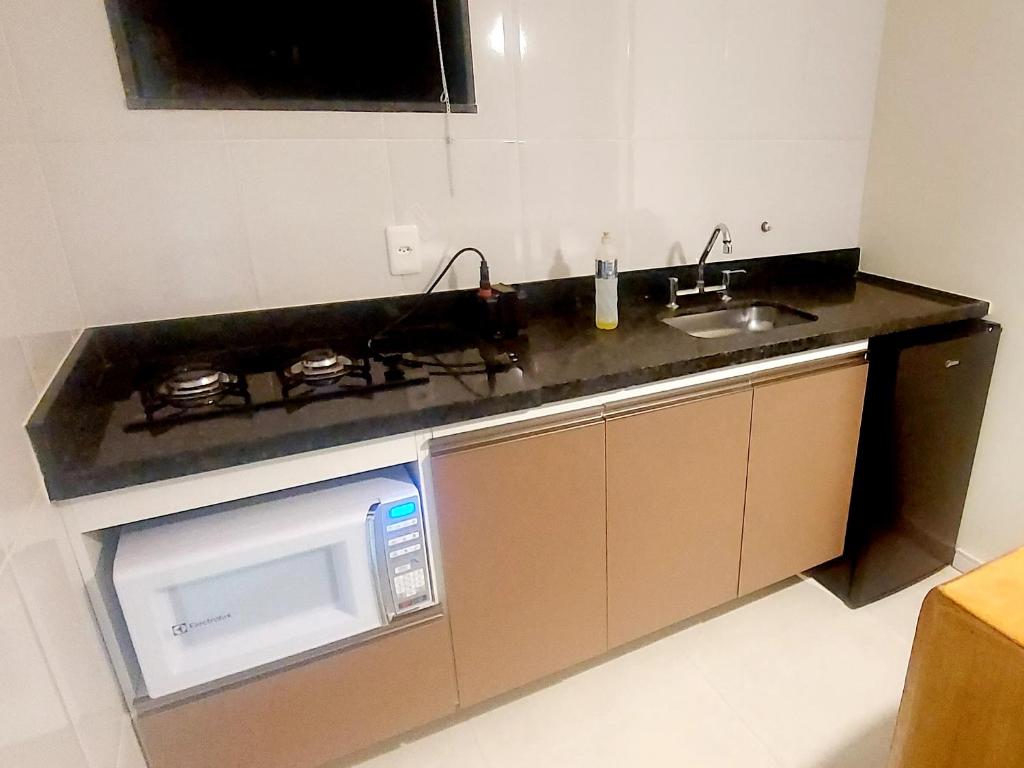 a kitchen with a microwave and a sink at Chalé Quinta Garden in Nova Friburgo