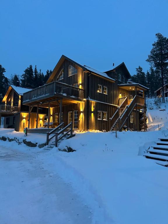 uma casa de log na neve à noite em Modern stuga nära skidbacken em Järvsö