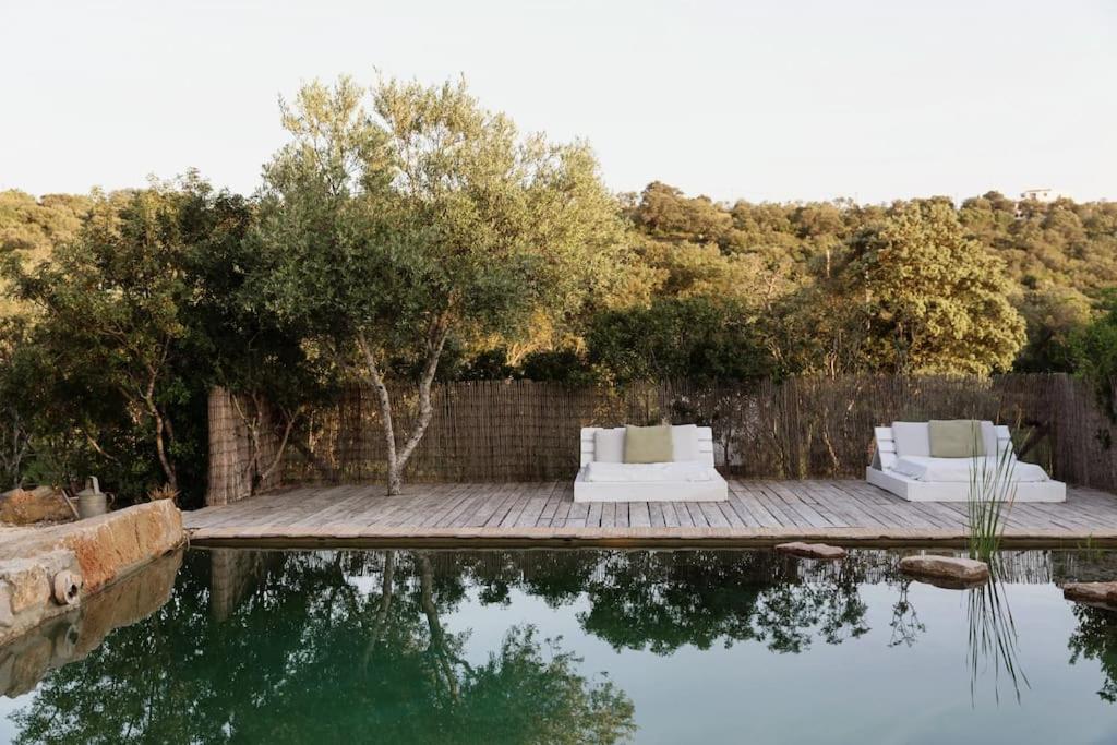 two white chairs sitting on a wooden deck next to a body of water at Casa Brava - Algarve in Loulé