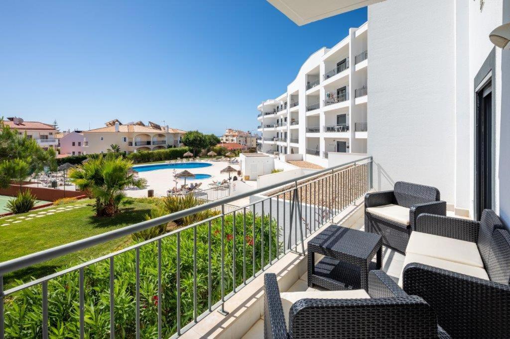 a balcony with chairs and a view of a pool at Appartement Vista das ondas in Olhos de Água